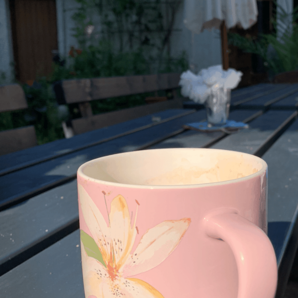 die ersten Morgenkaffeetasse im Freien auf einem dunklen Tisch